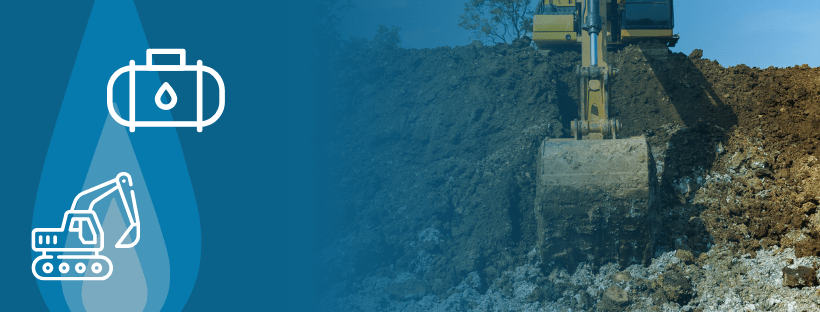 A construction machine stands beside a large dirt pile, excavating for an underground propane tank installation.